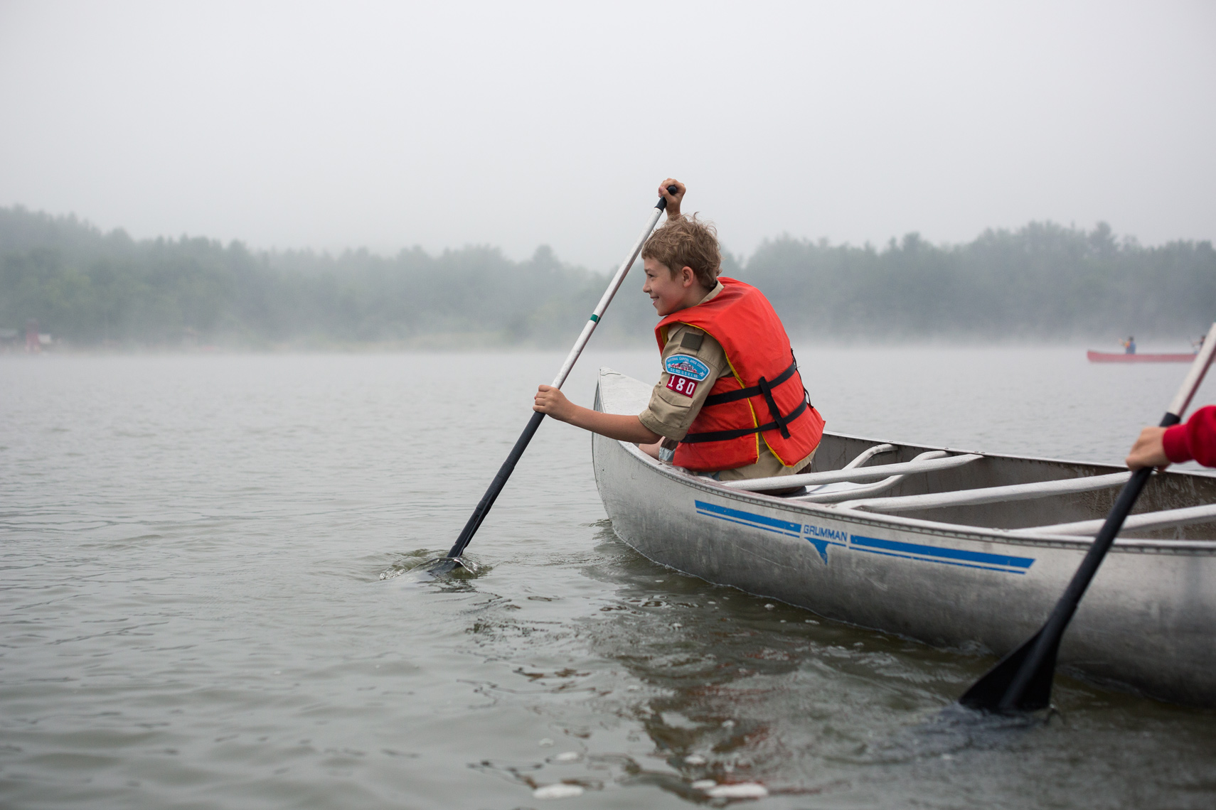 boy scout paddling canoe on lake, washington dc photojournalism