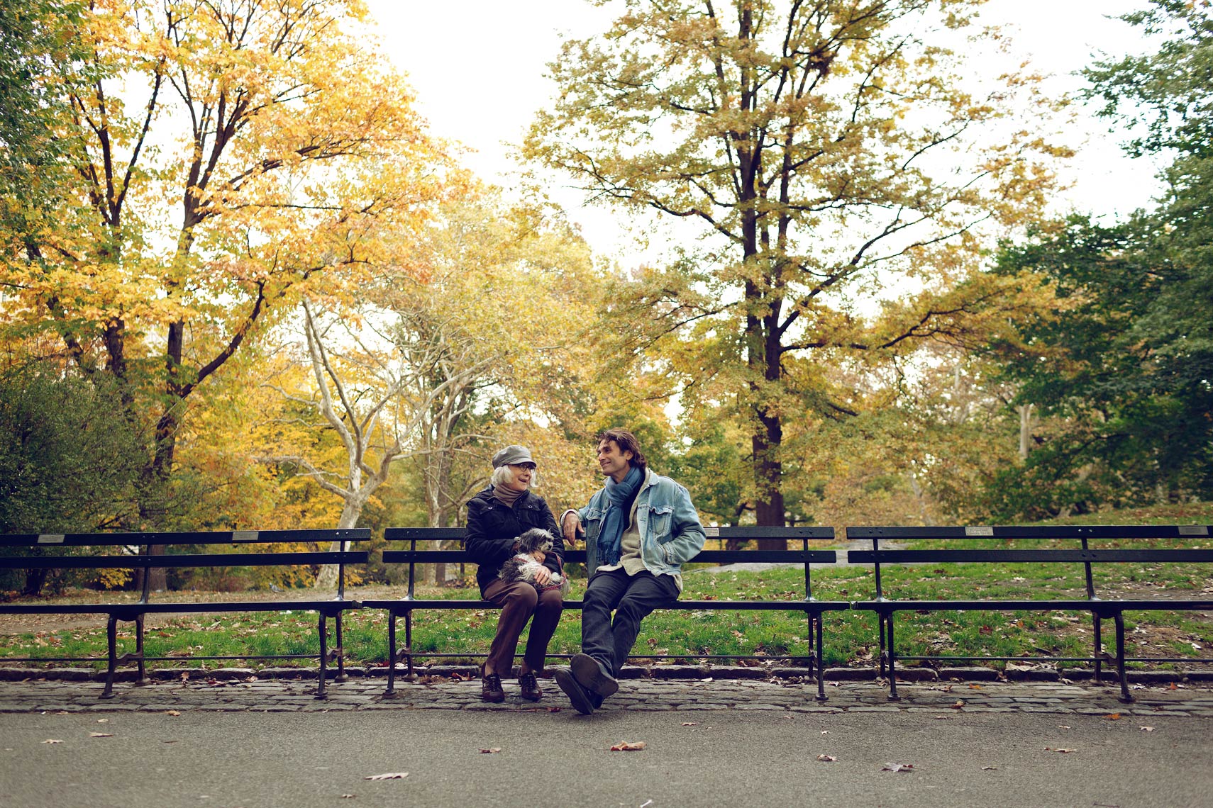 elderly mother and son sitting on park bench for washington dc advertising photographer