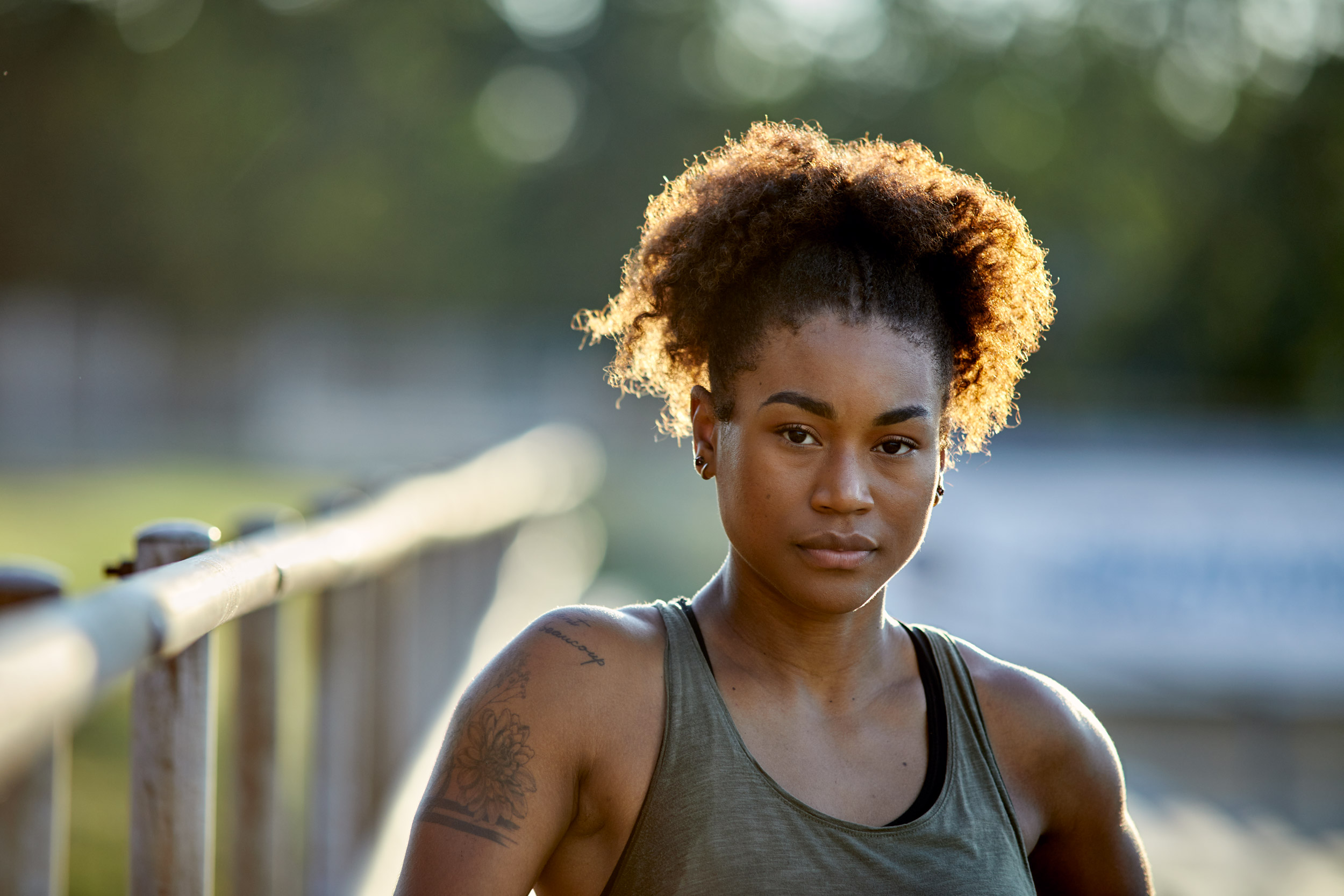 A female athlete poses for a portrait after an intense workout.