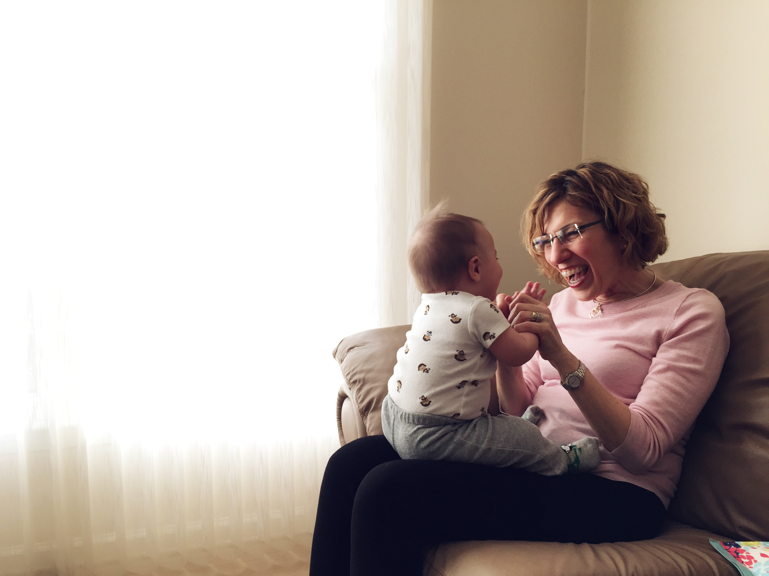 grandmother playing with baby by window for washington dc advertising photography
