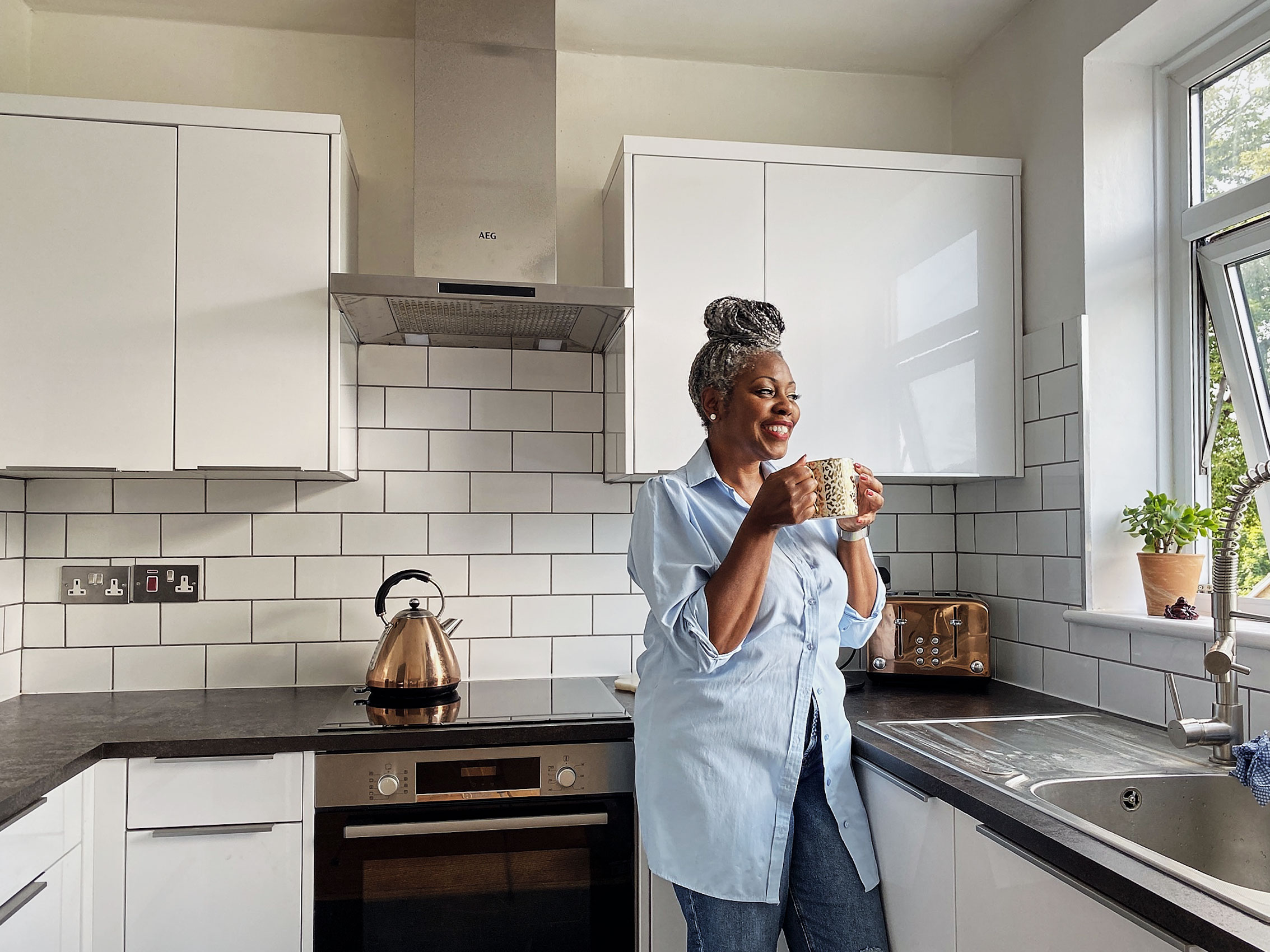 gray-haired-woman-sipping-coffee-in-kitchen-dc-commercial-photography-eli-meir-kaplan