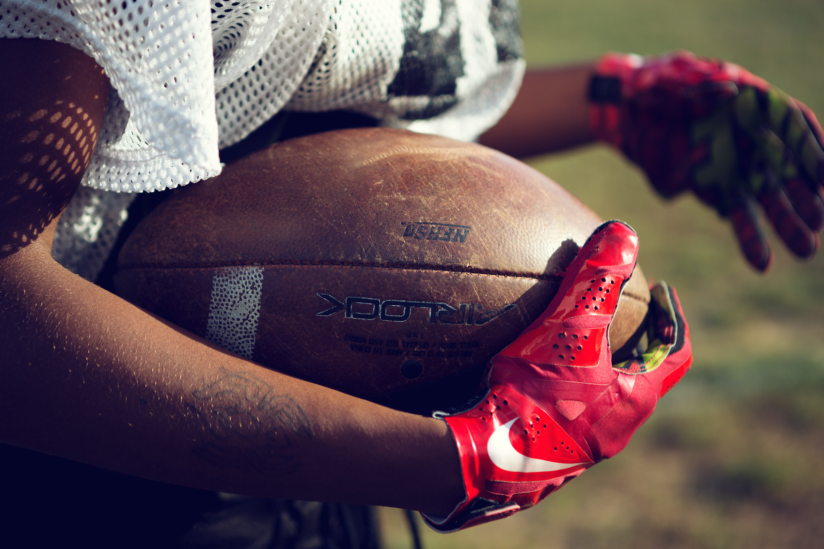 high school football player carrying football for washington dc commercial photography