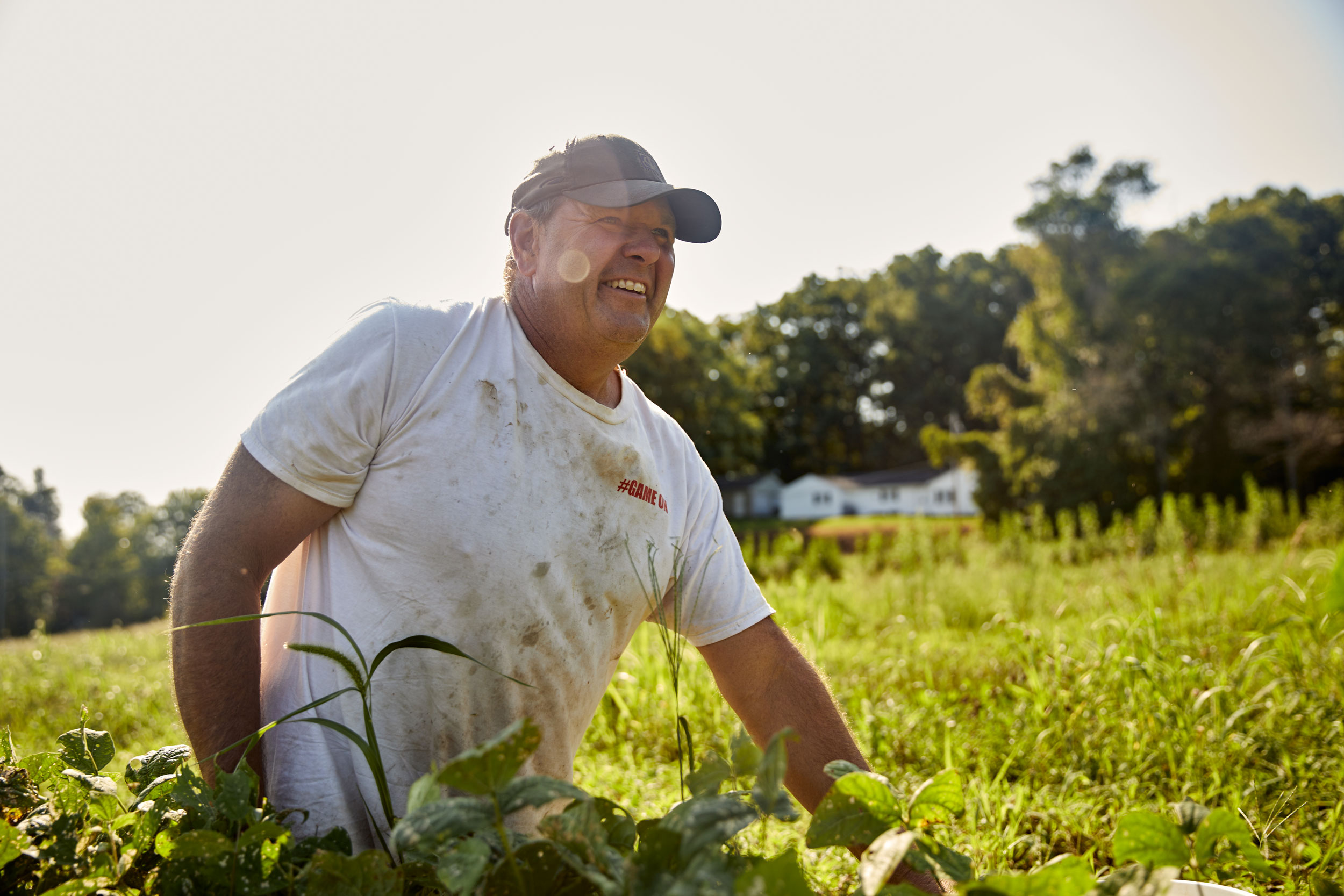 Farmer Jack Gurley laughs while tending to produce on Calvert