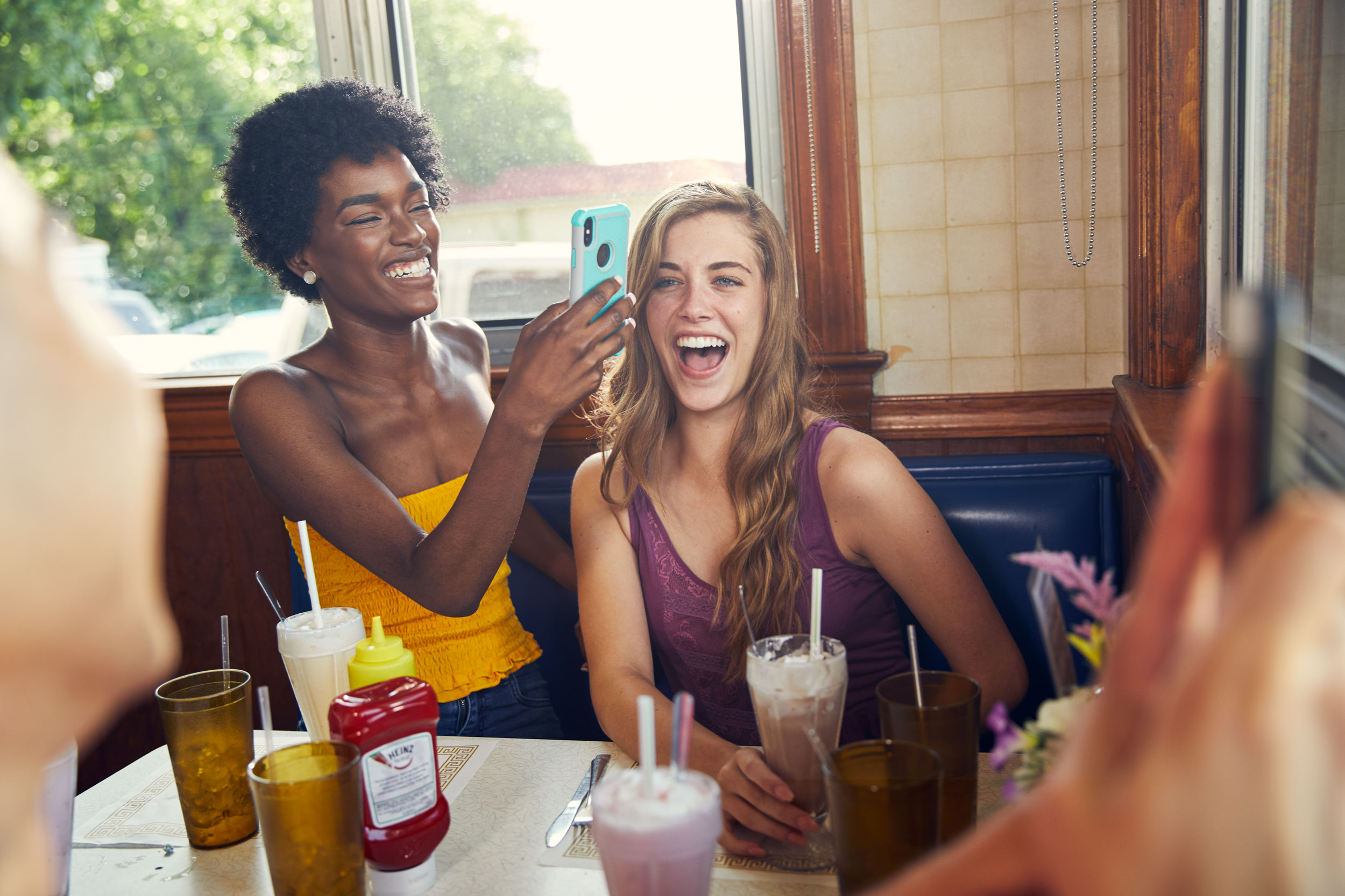 millennials take pictures with phones at diner for washington dc commercial photography