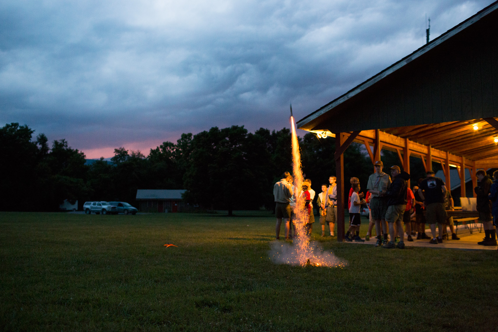 boy scouts launching model rocket under cloudy sky, washington dc photojournalism