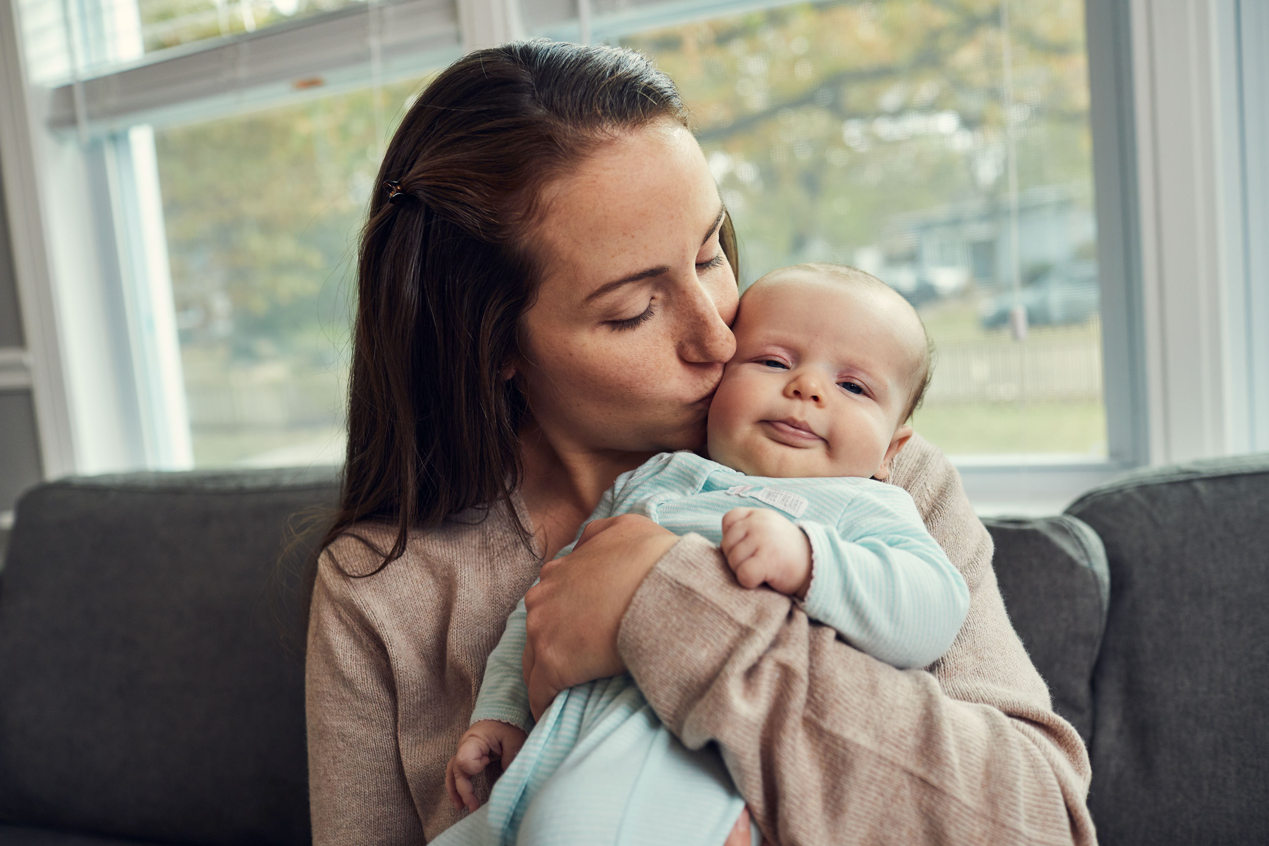 mom kissing baby by window, washington dc commercial photography
