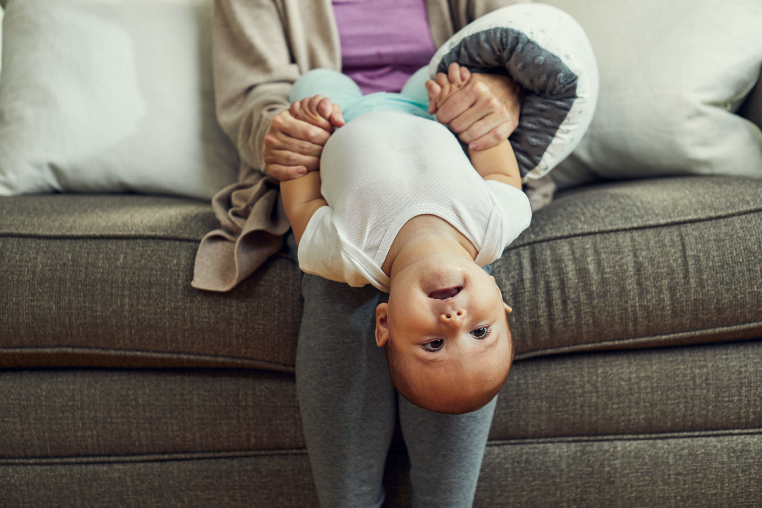 mom with breastfeeding pillow holding baby upside down, washington dc advertising photography
