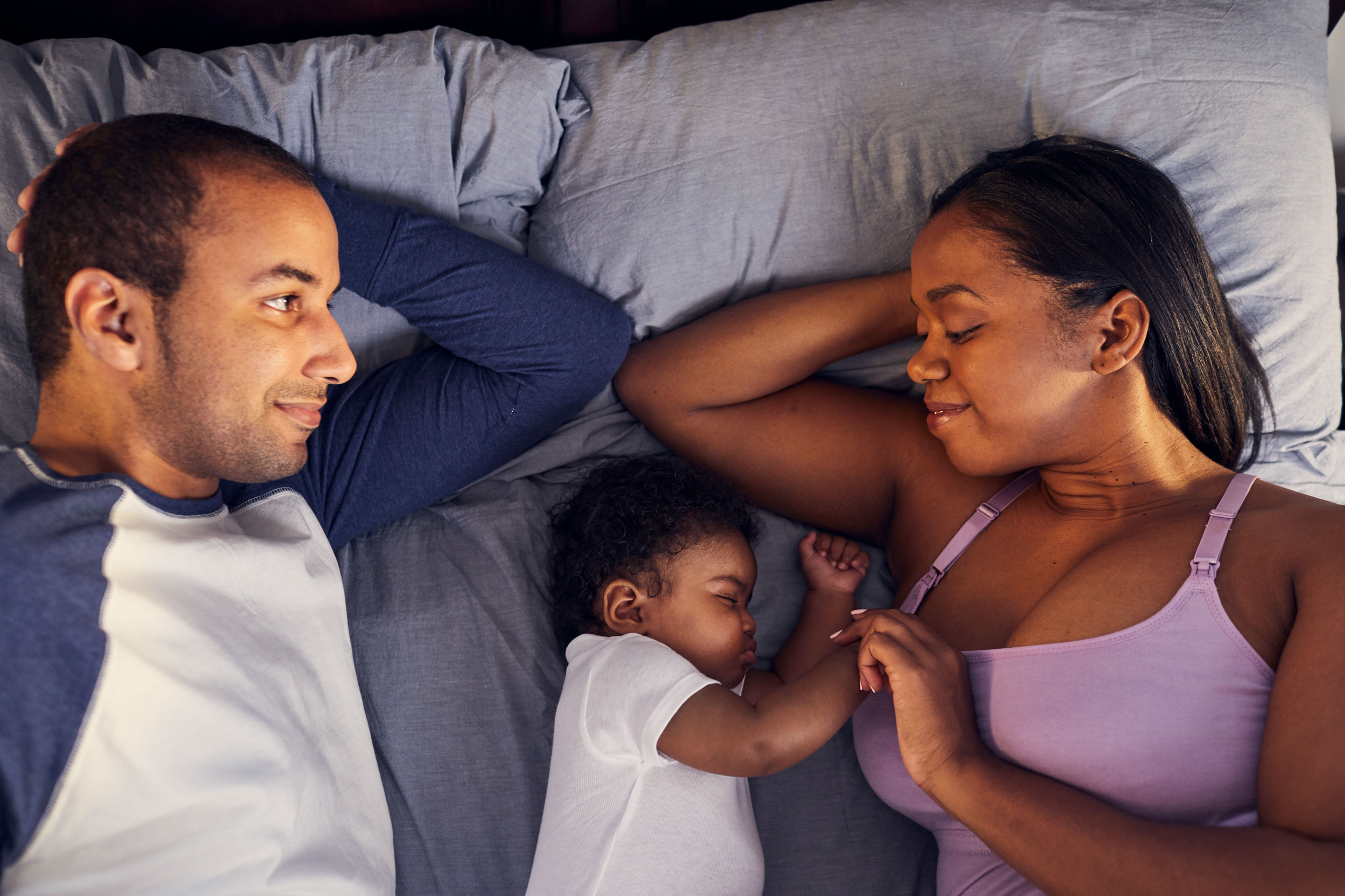 mom and dad resting with baby in bed, washington dc commercial photography