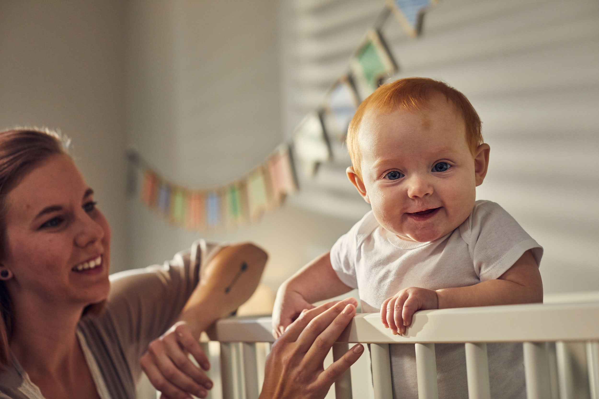 smiling redheaded baby in crib with mom, washington dc commercial photography