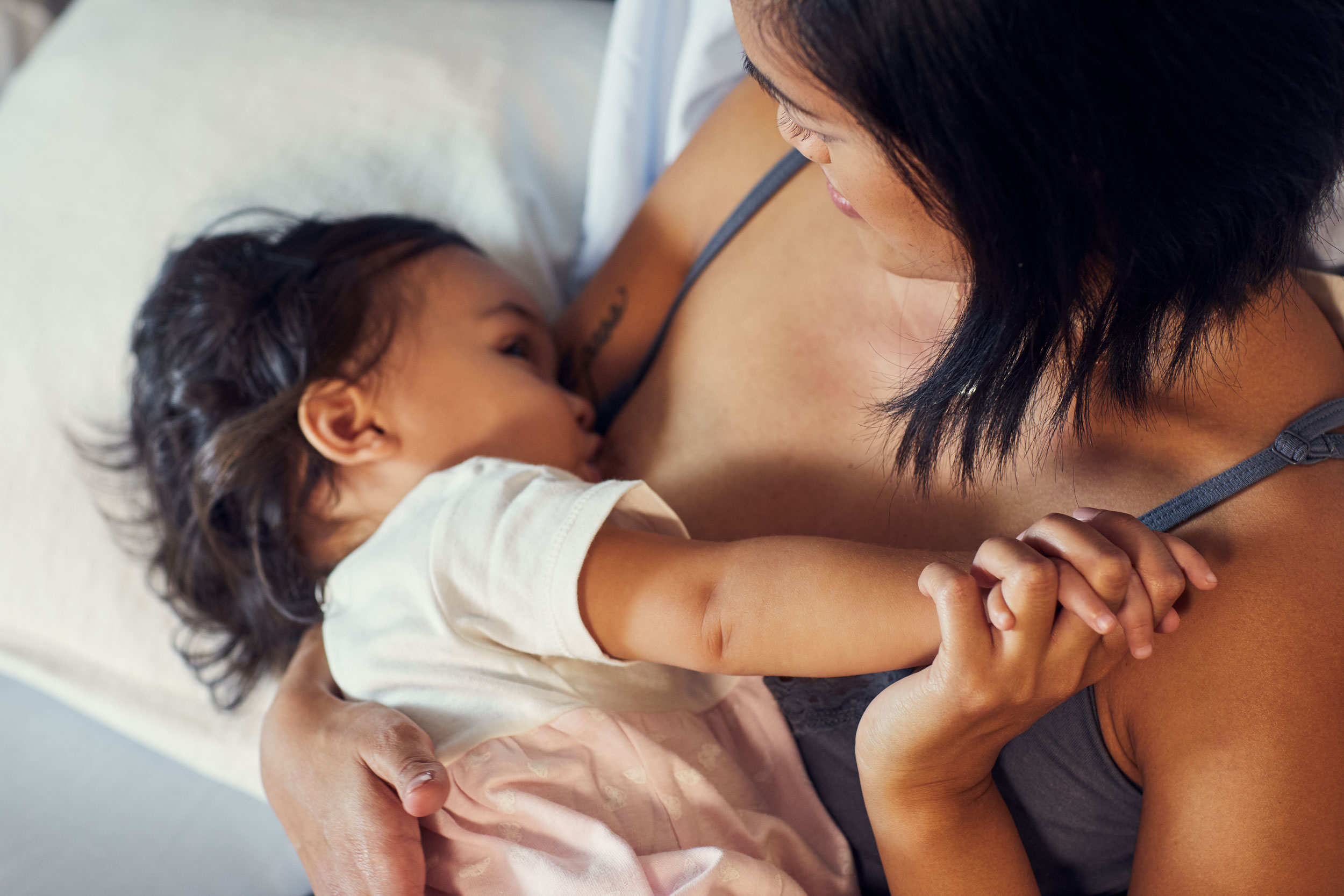 mom breastfeeding baby while holding hands, washington dc commercial photography