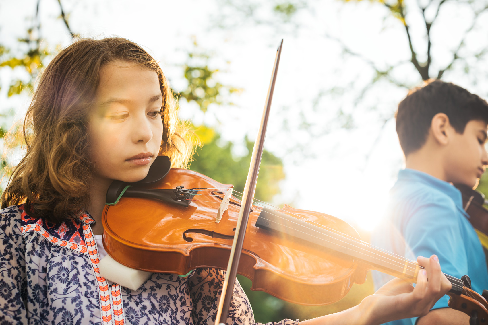 adolescent girl playing violin outside