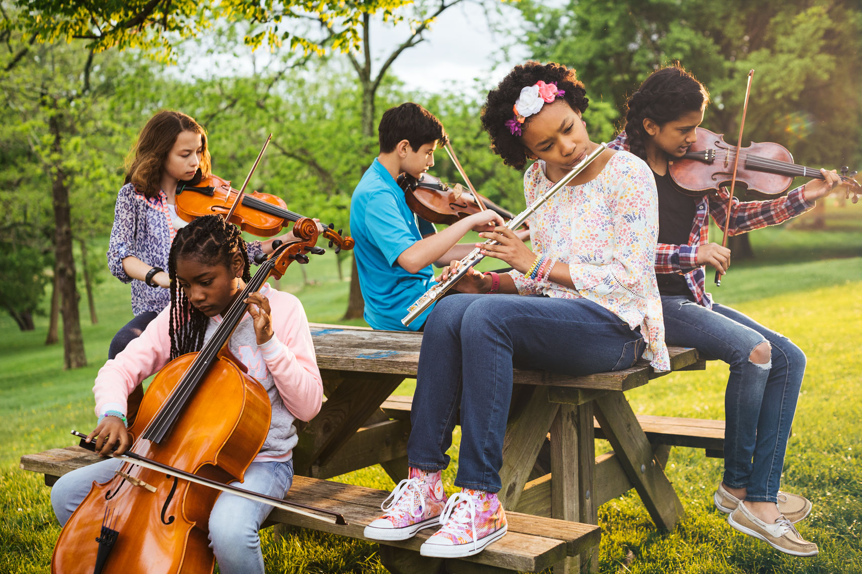 group of kids playing musical instruments on picnic table