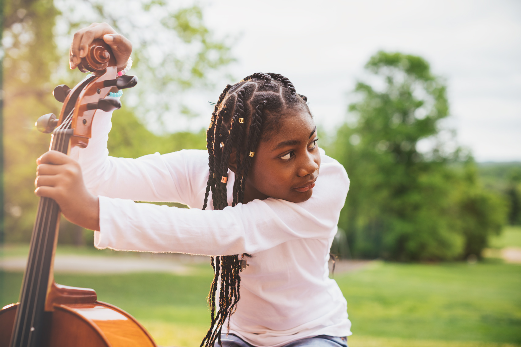 adolescent girl holding cello fingerboard outside, washington dc commercial photography