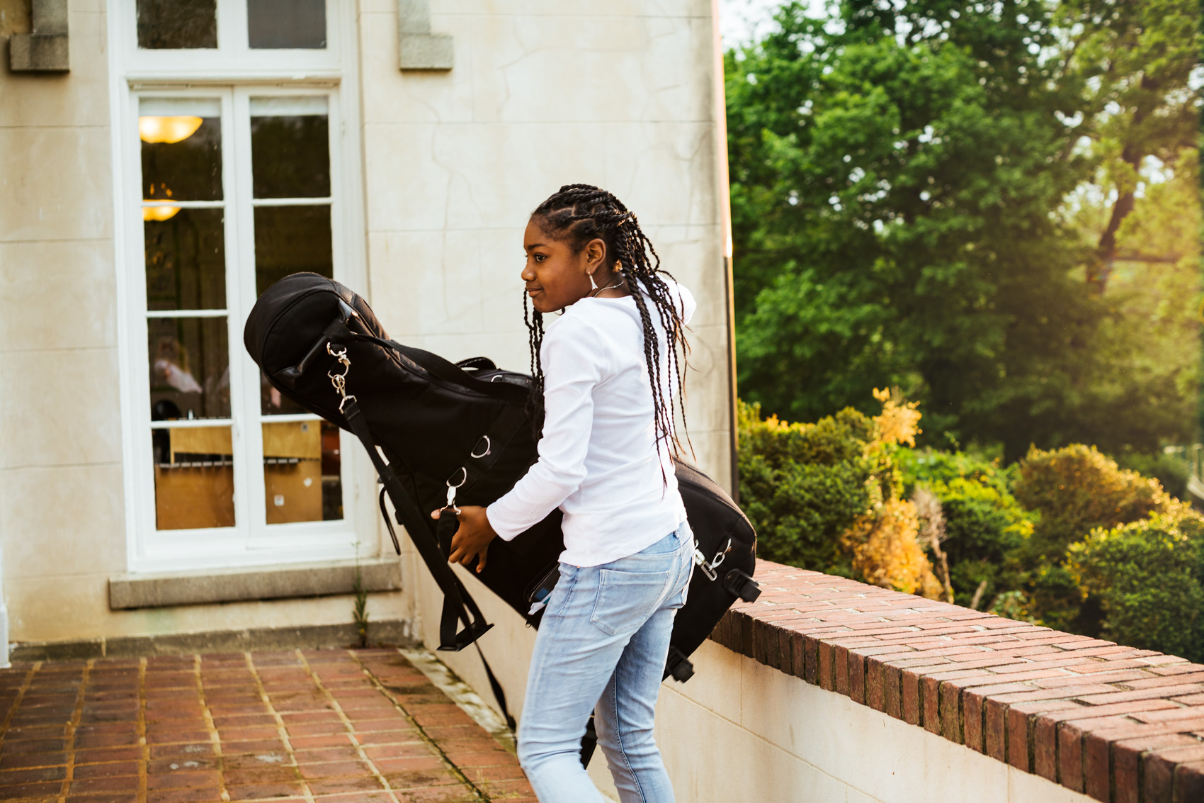 adolescent girl carrying cello case outside, washington dc commercial photography