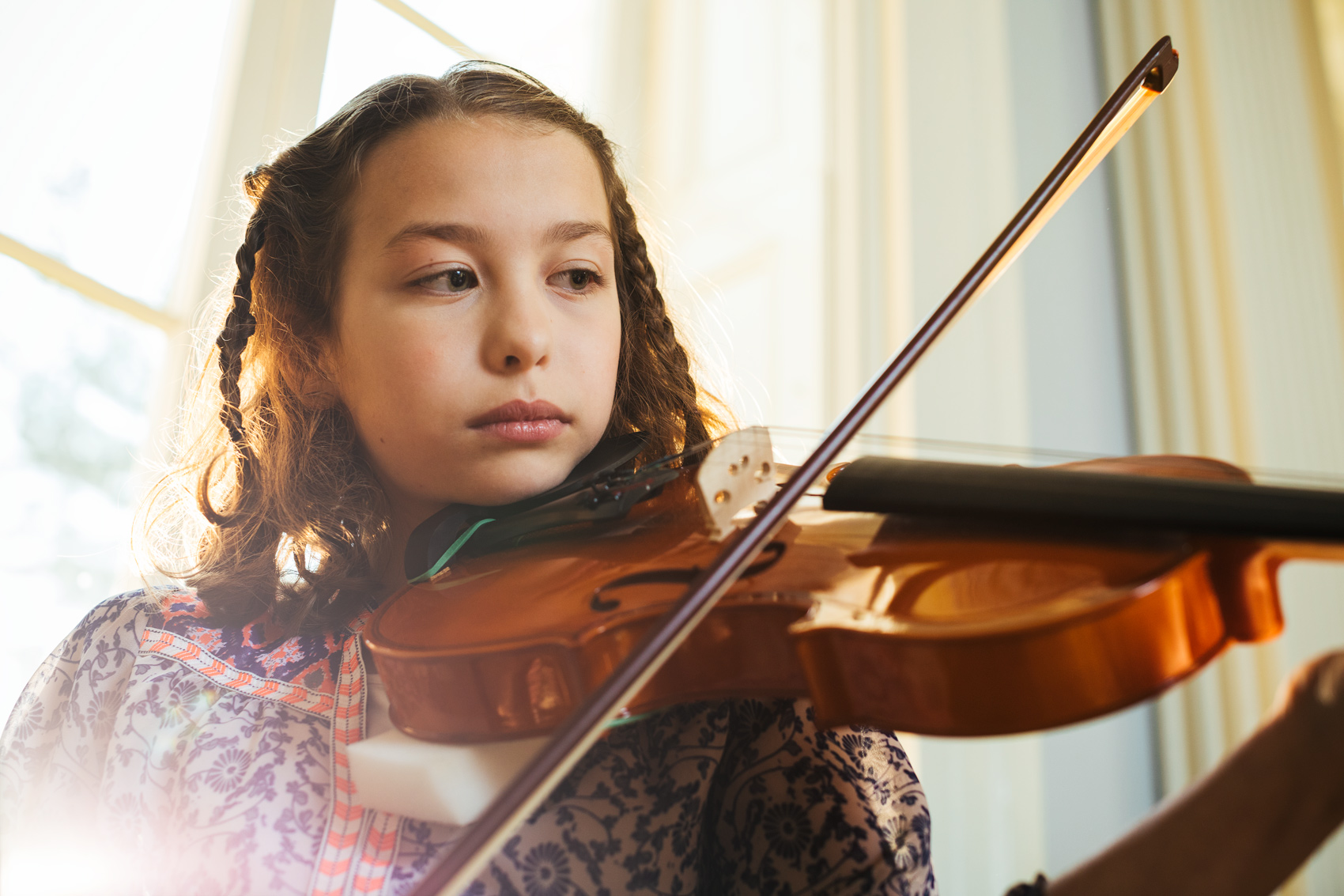 girl playing violin inside by window, washington dc commercial photography