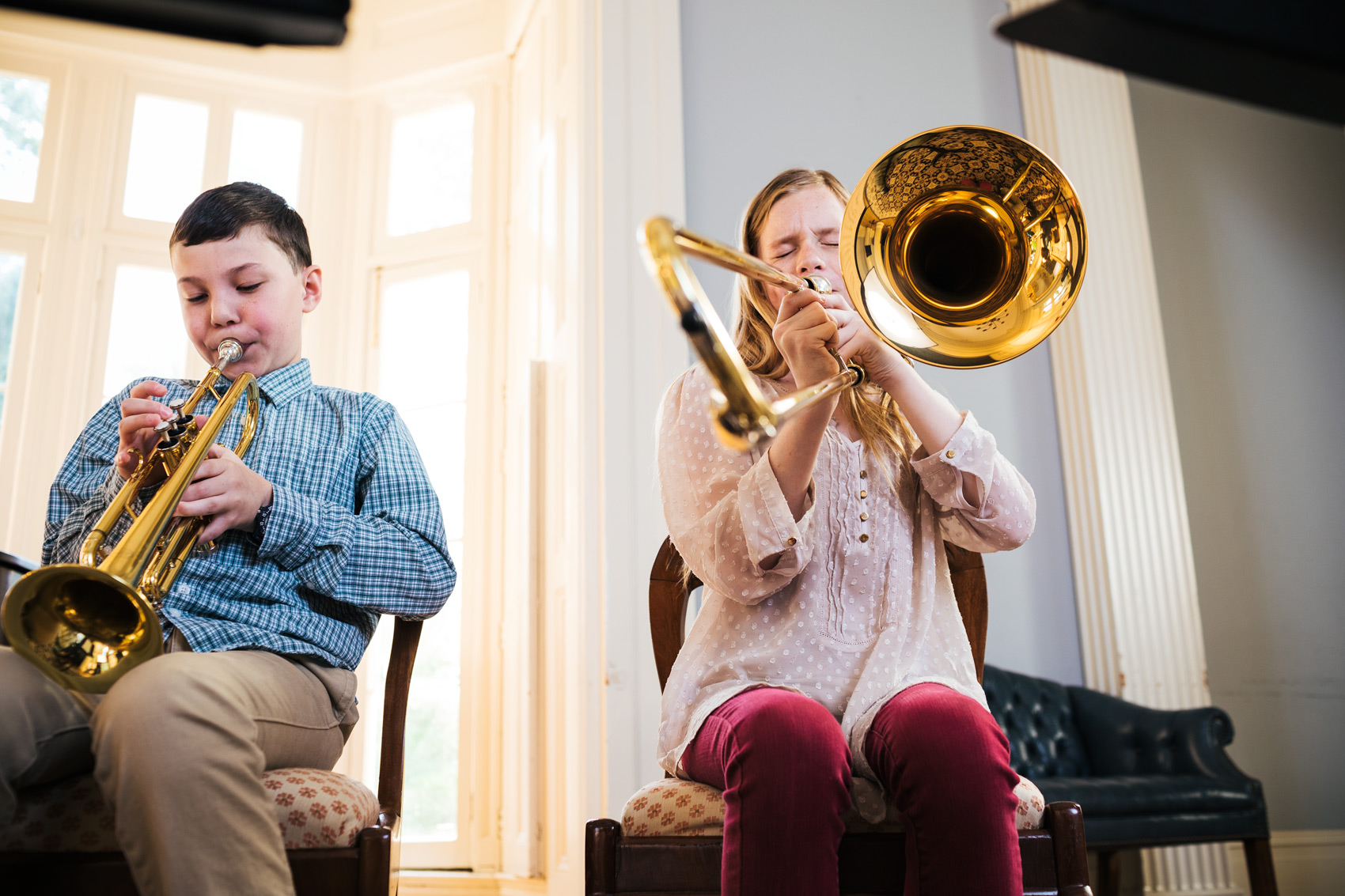 boy and girl playing horns by window, washington dc commercial photography