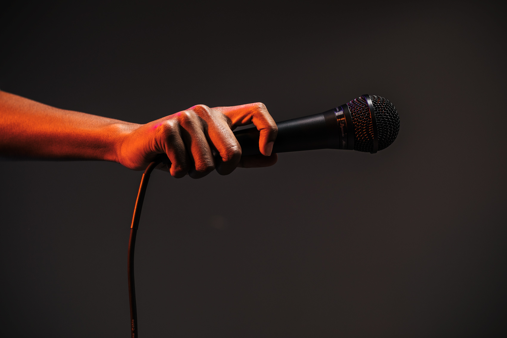 hand holding microphone under red light, washington dc commercial photography