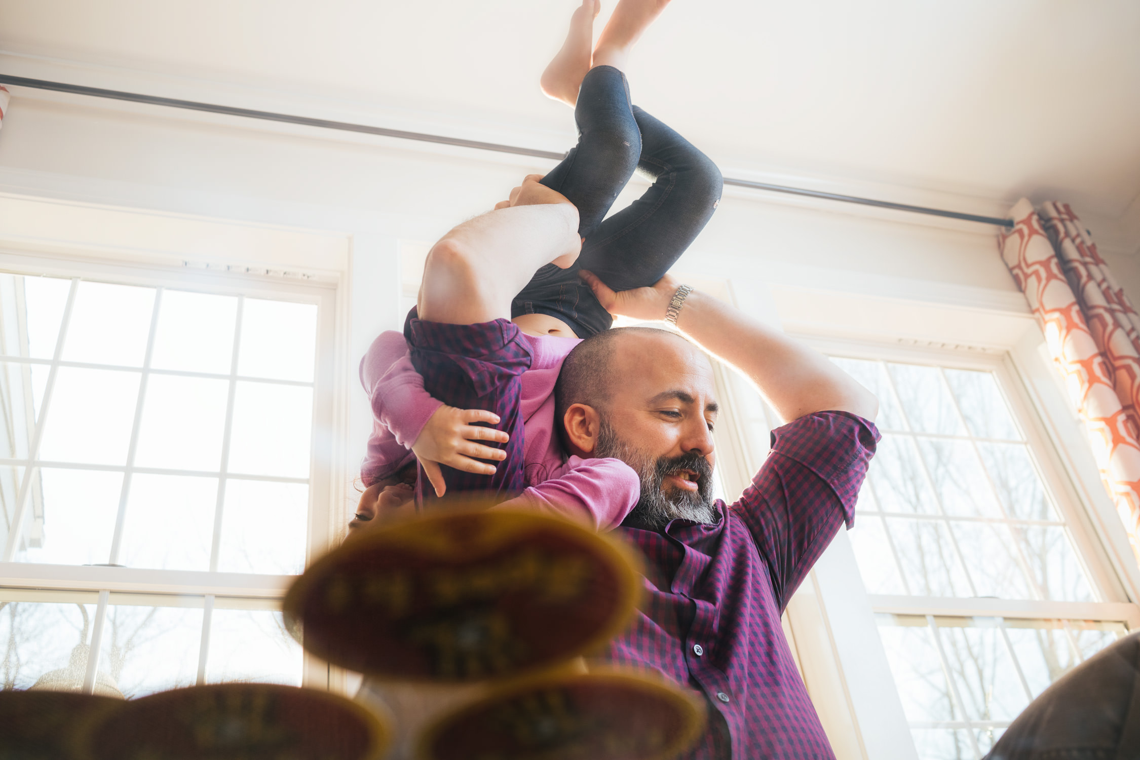 father flipping daughter by window, washington dc commercial photography