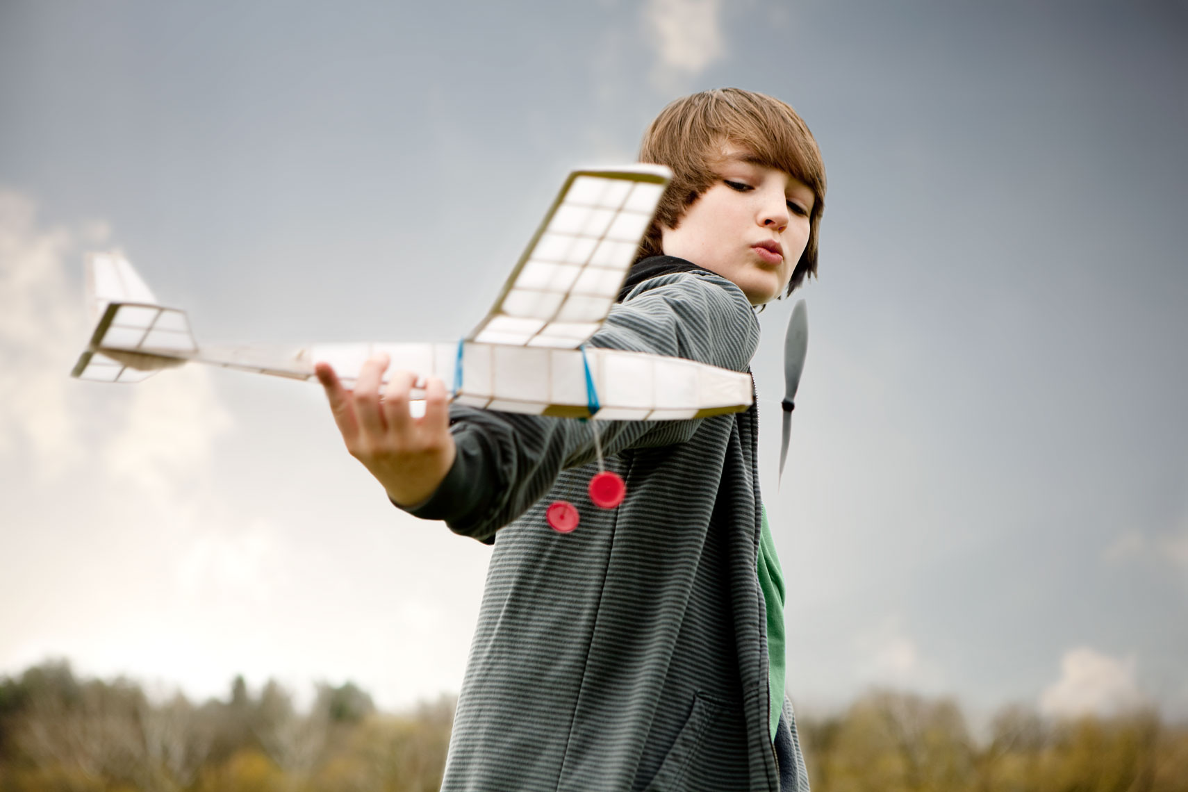 A boy flies his toy airplane.