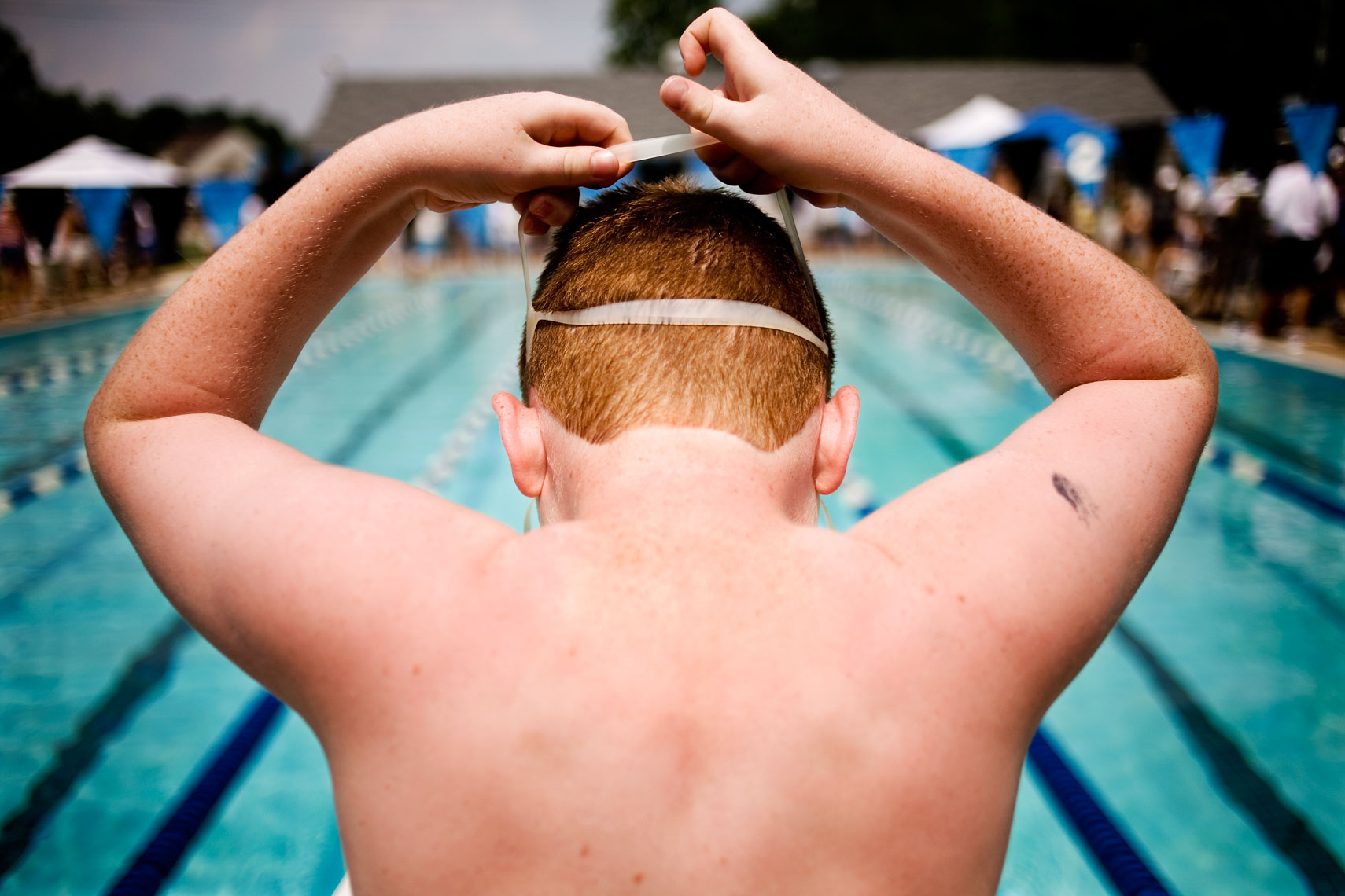 boy strapping on goggles at pool for washington dc editorial photography