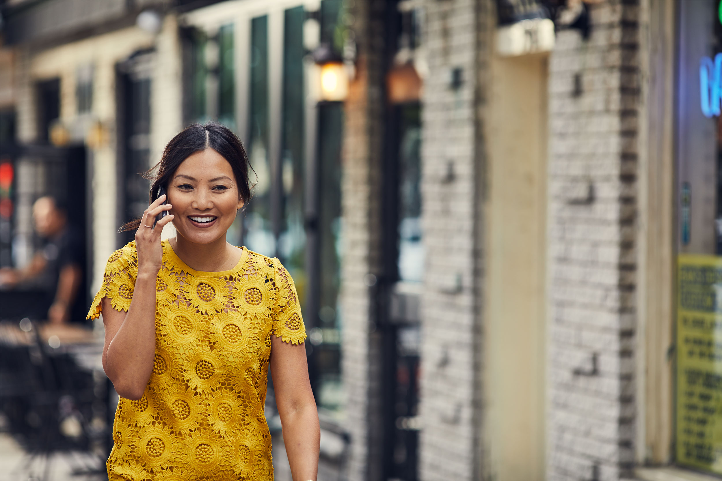 woman in yellow dress talking on smartphone on street, washington dc commercial photography